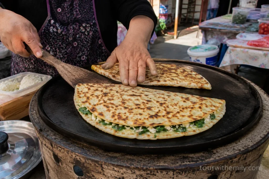 Turkish gözleme flatbread being cooked on a griddle at a local street food stall in Cappadocia