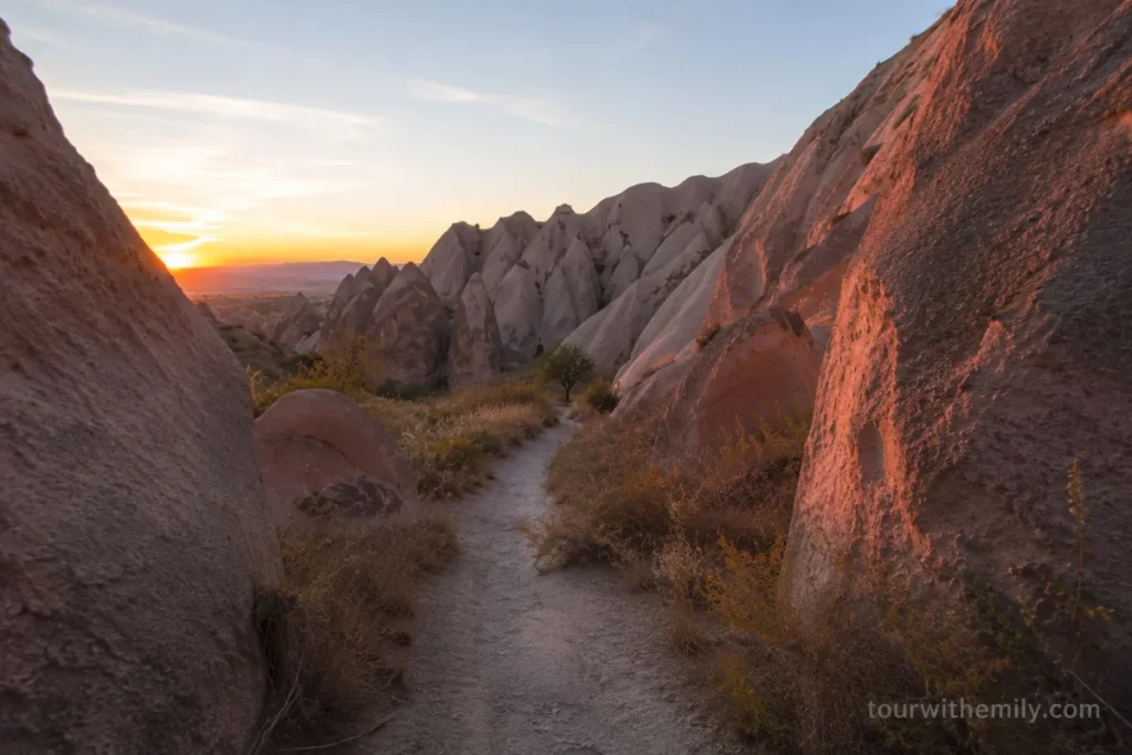 Rose Valley Cappadocia at sunset with rock formations glowing pink and deep red in the evening light