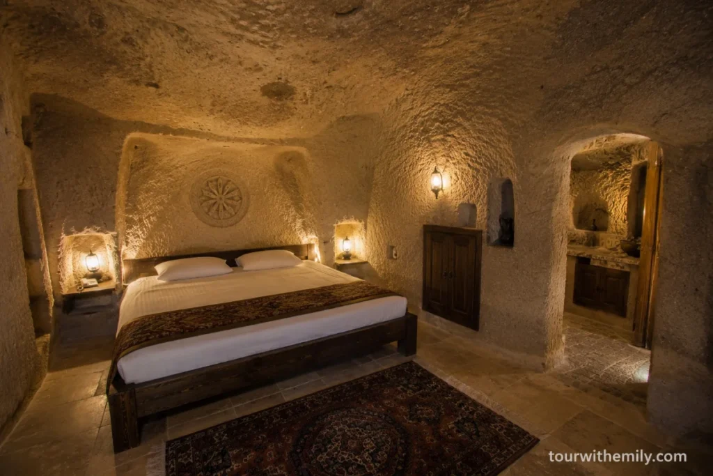 Interior of an authentic carved rock cave hotel room in Cappadocia with uneven stone ceiling
