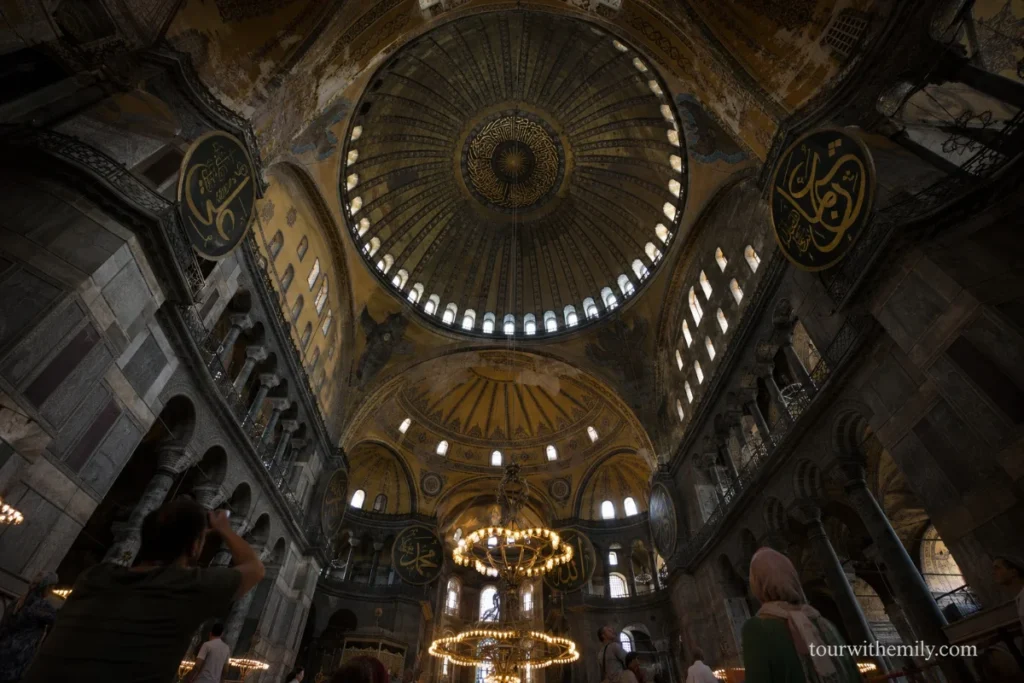 Interior of Hagia Sophia Istanbul showing the massive central dome with Byzantine mosaics and Ottoman calligraphy medallions