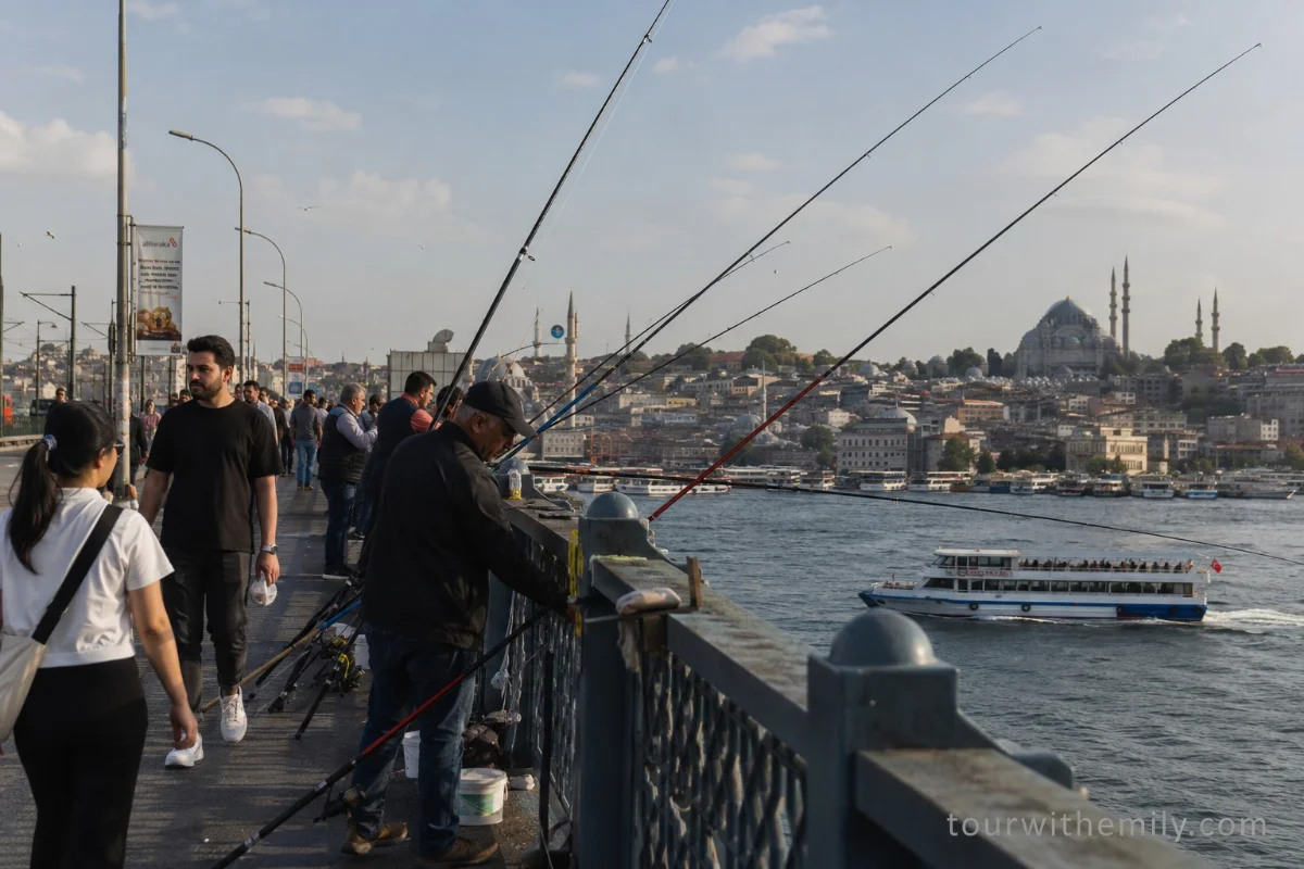Galata Bridge Istanbul with fishermen on the upper rail and the Sultanahmet skyline with mosque minarets in the background