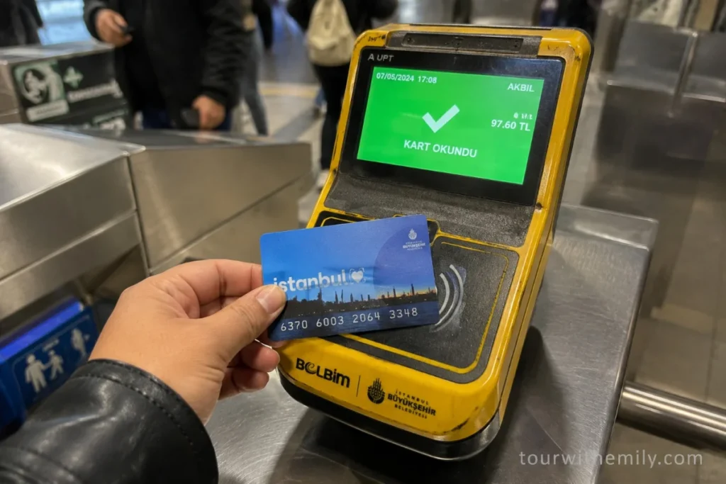 Person tapping an İstanbul Kart transit card on a turnstile at an Istanbul metro or tram station
