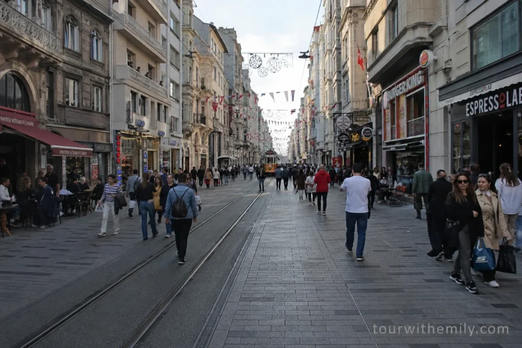 Busy pedestrian İstiklal Avenue in Beyoğlu Istanbul with shops cafes and crowds of people walking
