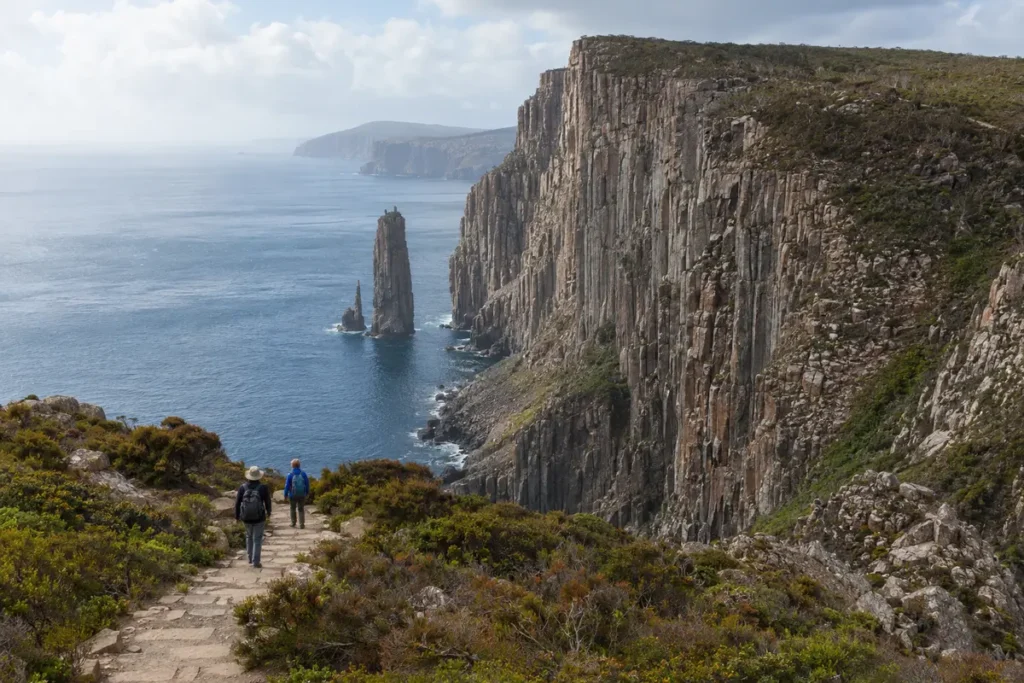 Hiker overlooking dramatic sea cliffs at Cape Hauy in Tasmania