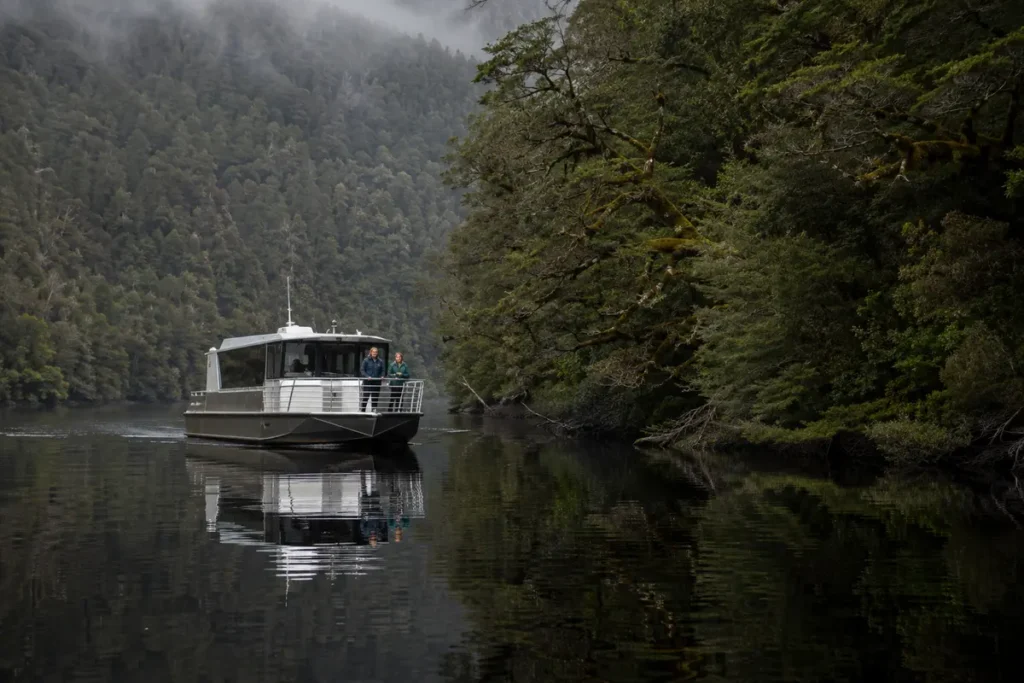 Boat cruising the Gordon River through Tasmania's western wilderness